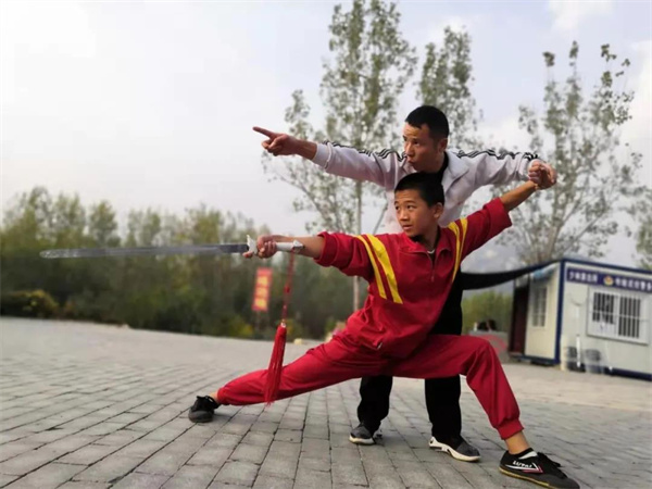 少林寺武校教练指导学生练习武术动作